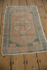 Vintage Distressed Oushak rug's worn beige pile and seafoam green geometric border.