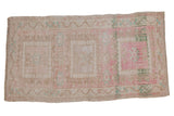 Distressed Oushak rug, faded geometric medallions in blush pink and warm beige.