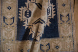 Folded vintage Oushak rug, dark blue serrated motifs on distressed abrashed ground.