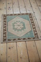 Vintage Distressed Oushak corner shows seafoam green geometric medallion and brown vine border.