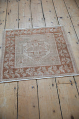 Upper corner of distressed vintage Oushak rug with copper bronze plant motifs.