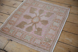 Distressed Oushak rug corner with intact side selvage, pink and copper floral border.