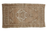 Distressed vintage Oushak rug with a soft ivory medallion and muted beige field, 2' x 3'7