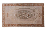 Distressed Vintage Oushak rug mat with stepped medallion, antique ivory, copper bronze, beige.
