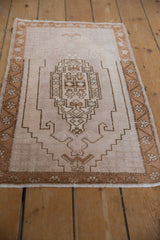 Distressed vintage Oushak rug mat displaying geometric stepped medallion and floral border.