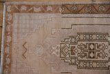 Vintage Oushak rug corner: short pile, floral meandering vine border, stepped motifs.