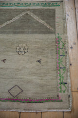 Stepped mehrab outline of the distressed Oushak rug, showing subtle floral and time-softened silver tones.