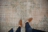 Distressed texture of vintage Oushak carpet in ivory, seafoam green, and pale coffee brown.