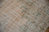 Distressed Oushak rug pile featuring mostly even wear, ivory, pale coffee, and seafoam green.