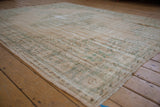 Worn pile texture of a distressed vintage Oushak rug with faded ivory and seafoam green.