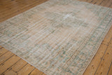 Distressed vintage Turkish Oushak rug corner, with mostly even wear on ivory and green pile.