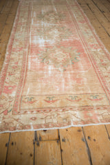 Distressed pink, ivory, and seafoam green floral border detail on a vintage Oushak runner.