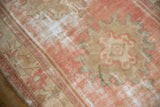 Distressed Oushak rug pile, showing blush, beige, and exposed foundation.