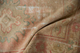 Distressed pile of vintage Oushak runner showing blush, seafoam green, and visible foundation.