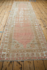Distressed Oushak runner with intentional wear, featuring dusty rose and ivory tones.