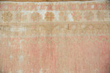 Soft, worn pile of a distressed vintage Oushak runner in dusty rose and beige hues.