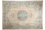 Distressed vintage Oushak rug: faded beige field, sky blue medallion, and floral vinery.