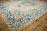 Vintage distressed Oushak rug, beige field, visible pile wear, and sky blue corner.