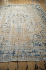 Distressed Oushak rug detail: worn pile, dusty navy motifs on an abrashed ivory ground.