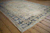 Decorative worn dusty navy border and beige abrashed field on a vintage Oushak rug corner.