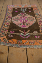 Distressed Kars rug's tangerine border, aqua green accents, and fuchsia geometric motifs.
