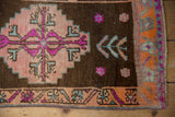 Distressed Kars rug corner with pink, fuchsia, aqua stepped motifs and tangerine border.