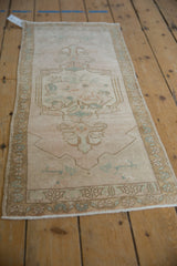 Close-up of palmette finials and spandrels on the distressed Oushak rug in pale tones.