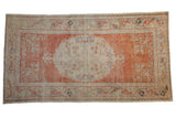 Vintage distressed Oushak rug: faded cinnabar red field, pale blue-ivory medallion and borders, 3'5