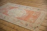 Pale cinnabar and blue ribboned corner motif on a distressed vintage Oushak rug.