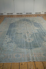 Distressed vintage Oushak rug with worn hand knotted pile revealing foundation.