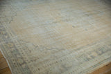 Distressed texture on a vintage Oushak rug, showing soft ivory, sand, and pale blue tones.
