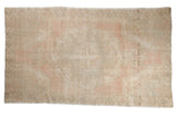 Distressed vintage Oushak rug with blush medallion, ivory field, faded floral patterns, 4'6