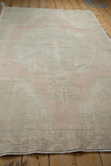 Distressed vintage Oushak rug showing faded blush and ivory with visible wear.