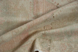 Distressed vintage Oushak rug pile texture showing wear, blush, ivory, and sea foam colors.