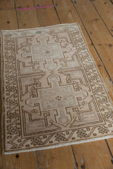 Distressed Oushak rug mat with geometric medallions, even wear, and faint foundation showing.
