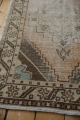 Worn texture and visible foundation on this distressed Oushak runner, with muted geometric patterns.