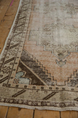 Distressed Oushak runner: geometric border with stepped brown pattern and visible foundation.