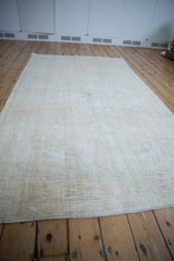 Heavily textured, distressed surface of the vintage Oushak rug showing worn pile and faint green.