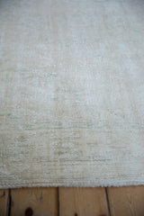 Distressed ivory and beige vintage Oushak rug pile with visible foundation and seafoam green.