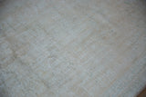 Textured distressed Oushak carpet with worn pile, visible knot heads, and neutral tones.