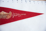 Close-up of vintage red felt pennant with white 'Souvenir of Portland Ore.' text.