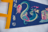Vintage Chinatown felt flag graphic: blue-green dragon, pink accents, building.
