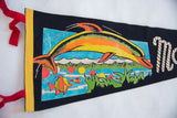 Vibrant multi-colored dolphin and fish graphic on the vintage Marineland of the Pacific flag.