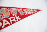 Detail of vintage Yellowstone Park felt pennant, showcasing colorful Grotto Geyser and Morning Glory Pool graphics.