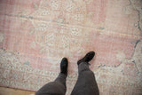 Faded pink and ivory Turkish Sparta carpet, showing distressed floral medallion and border.