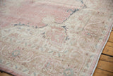Distressed vintage Turkish Sparta rug corner, softened pink, ivory, sand floral patterns.