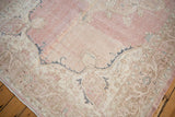 Vintage distressed Turkish Sparta carpet corner, abrashed pink field, floral arabesque border.