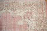 Distressed corner of a Sparta rug, with faded pink, ivory, and oxidized silver floral patterns.