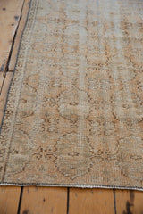 Distressed Oushak runner surface showing worn floral gul motif and visible foundation.