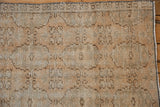 Textured pile and faded repeating floral gul motifs on the vintage distressed Oushak runner.